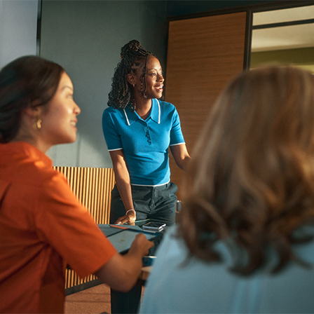 three women in conference room looking to the other side of the room